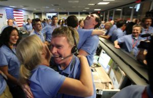 Ingénieur congratulant une collègue après atterrissage réussi de la sonde sur Mars, août 2012