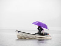 Femme avec parapluie dans une barque sur l'eau