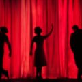 silhouettes sur fond de rideau rouge de théâtre