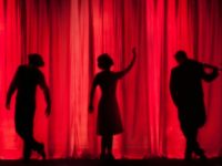 silhouettes sur fond de rideau rouge de théâtre