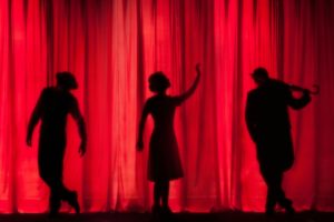 silhouettes sur fond de rideau rouge de théâtre