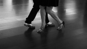 Jambes d'un couple de danseurs en mouvement, photo en noir et blanc